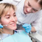 Protetyka Piotrków: Odbudowa uśmiechu z pomocą profesjonalnych rozwiązań 6 portrait dentist performing treatment patient 23 2148396220