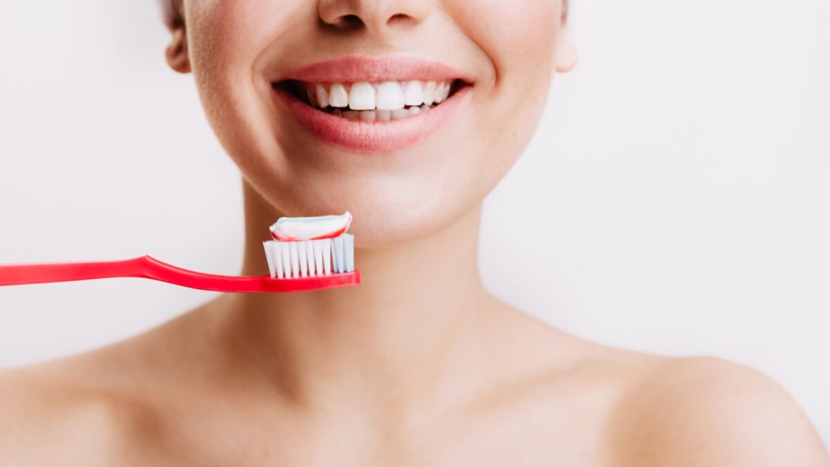 girl with sincere smile makes morning routine brushes her teeth isolated wall 197531 13926