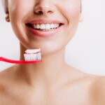 Dentysta Dental Piotrków – Twój zaufany specjalista w centrum miasta 7 girl with sincere smile makes morning routine brushes her teeth isolated wall 197531 13926